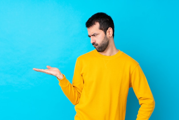 Uomo con la barba sopra la parete blu isolata