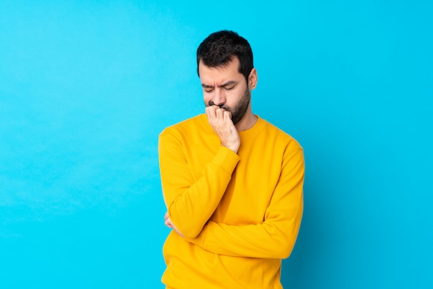 Uomo con la barba sopra la parete blu isolata