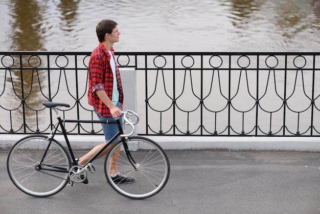 uomo con la bicicletta che cammina sulla banchina