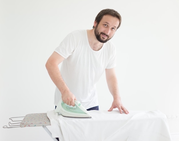 Uomo con la camicia da stiro barba prima di andare al lavoro