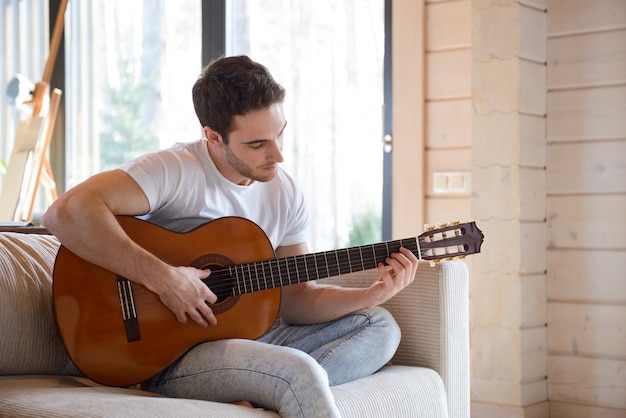 uomo con la chitarra seduto sul divano