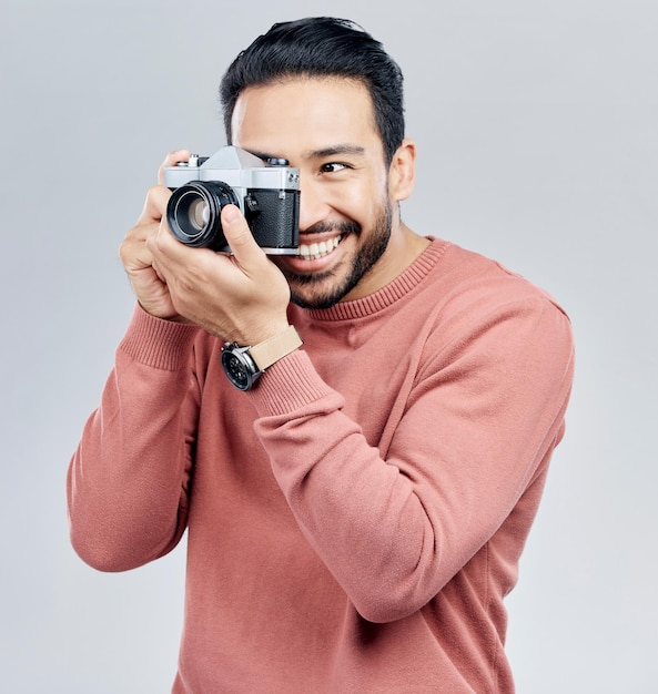 Uomo con la fotografia della fotocamera e felice con il sorriso che scatta foto con l'arte isolata sullo sfondo dello studio Fotografo felicità e creatività con tecnologia vintage con artista maschio creativo