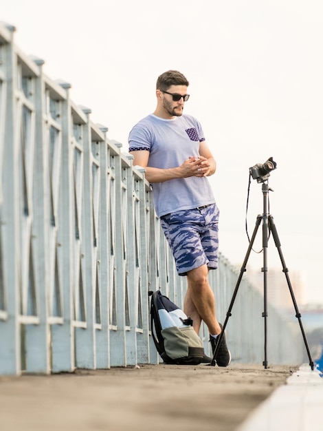 Uomo con la macchina fotografica su treppiede, scattare foto timelapse in città