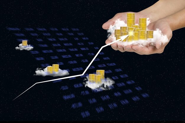 uomo con la mano che tiene pile di monete e nuvola sullo sfondo del cielo investimento aziendale e grafico di indicatori concetto