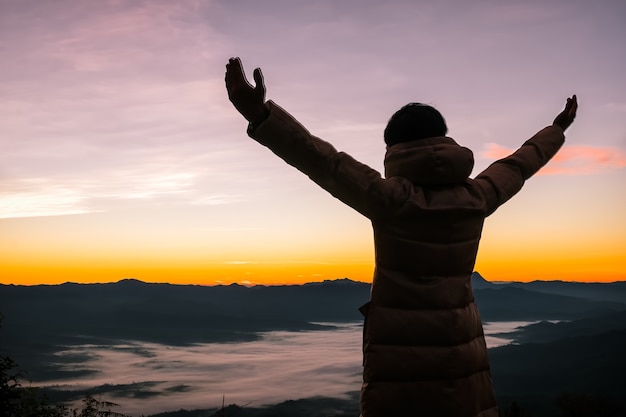 Uomo con le braccia alzate all&#39;alba bellissima