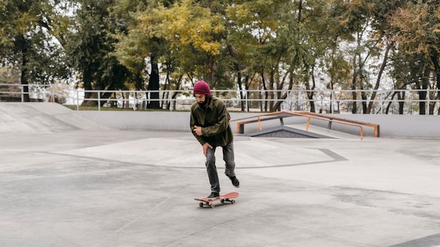 Uomo con lo skateboard nel parco