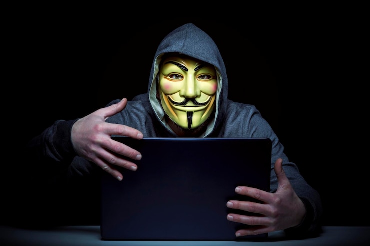 Foto uomo con maschera che usa un portatile sullo sfondo nero