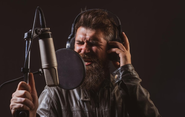 Uomo con microfono che canta musicista di canzoni nel primo piano espressivo del viso della sala da musica