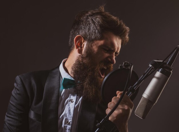 Uomo con microfono che canta un musicista nel music hall festival musicale ragazzo divertente che canta nel karaoke