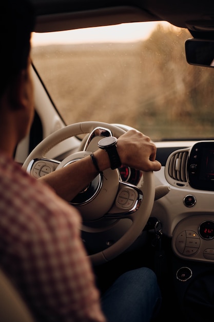 Uomo con orologio alla guida di un'auto