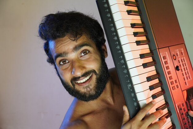 Uomo con pianoforte elettronico e sorridente