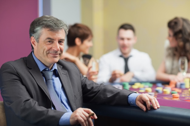 Uomo con sigaro pausa dal tavolo della roulette