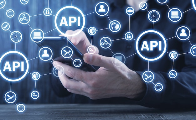 Uomo con smartphone. API. Interfaccia di programmazione applicazioni. Sviluppo software. Tecnologia