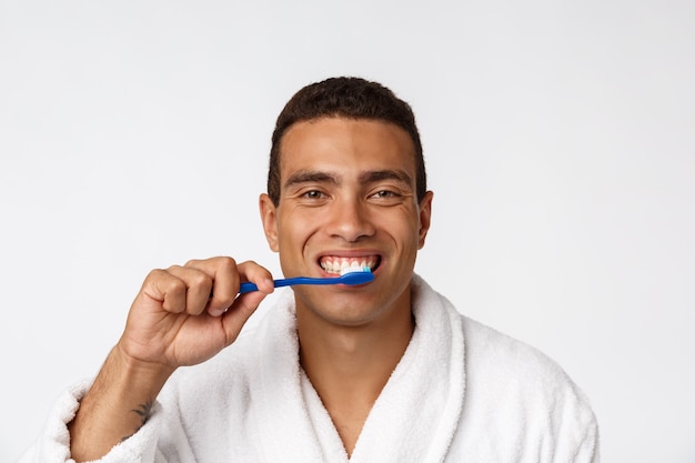 Uomo con spazzolino da denti. Uomo africano che tiene uno spazzolino da denti con lo spazzolino da denti e che sorride mentre stando