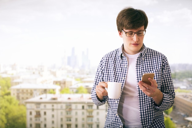 Uomo con telefono e caffè