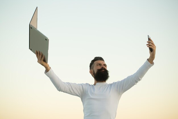 Uomo con telefono e laptop