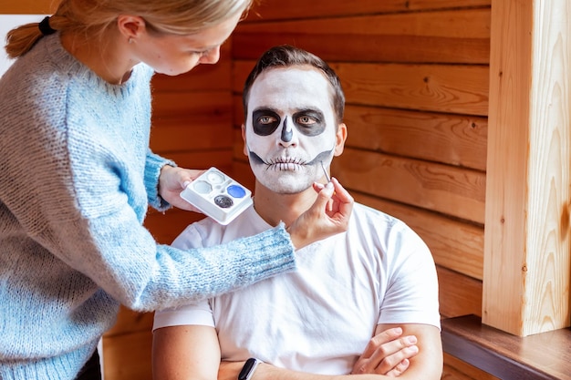 Uomo con trucco artistico spettrale in piedi preparato per la festa di Halloween