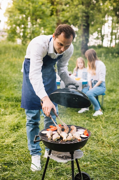 Uomo con un barbecue in natura