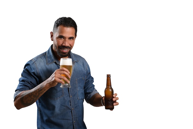 Uomo con un bicchiere di birra e una bottiglia di birra senza etichetta che sorride guardando la telecamera