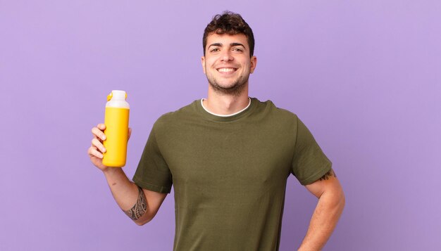 Uomo con un sorriso dolce e felice con una mano sull'anca e un atteggiamento fiducioso, positivo, orgoglioso e amichevole