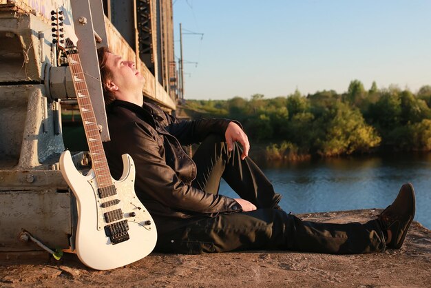 Uomo con una chitarra su una ferrovia