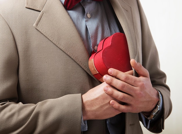 Uomo con una confezione regalo a forma di cuore