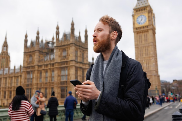 Uomo con uno smartphone in mano per le strade di Londra