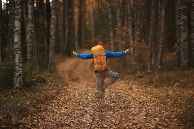 uomo con zaino una vista dal retro, escursioni nella foresta, paesaggio autunnale, la parte posteriore del turista con uno zaino