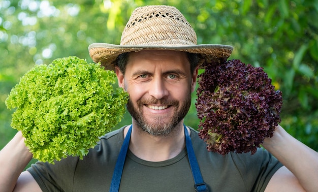 Uomo contadino in cappello di paglia con foglie di lattuga