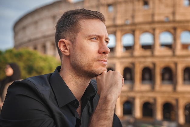 Uomo contemplativo che guarda il Colosseo durante l'ora d'oro a Roma