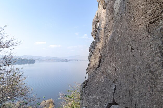 Uomo coraggioso che si arrampica su una roccia ripida