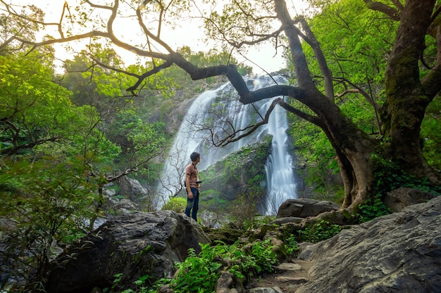 Uomo d'acqua che guarda una bellissima cascata Khlong Lan Waterfall National Park in Thailandia