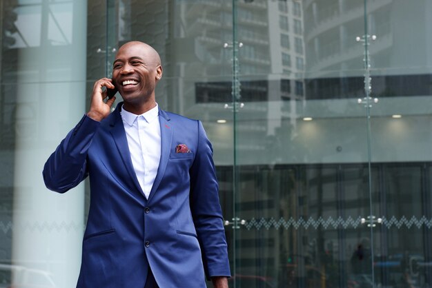 Uomo d&#39;affari africano che cammina e che parla sul telefono cellulare