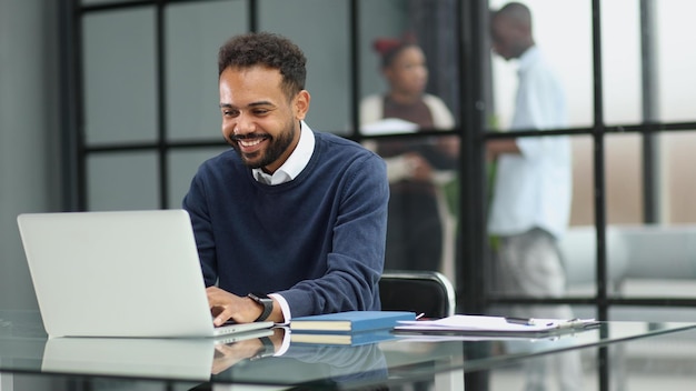 Uomo d'affari africano che lavora su un computer portatile in un ufficio