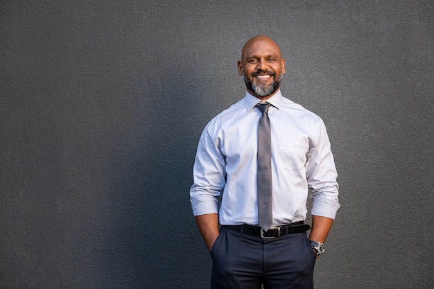 Uomo d'affari afroamericano che sorride sul gray