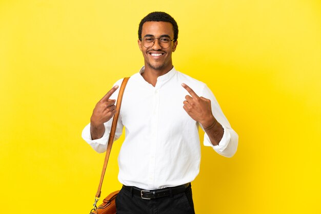 Uomo d'affari afroamericano su sfondo giallo isolato che dà un gesto di pollice in alto