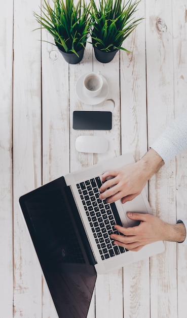 Uomo d'affari al lavoro. Vista superiore del primo piano dell'uomo che lavora al computer portatile