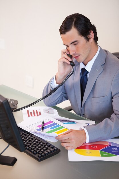 Uomo d&#39;affari al telefono parlando di statistiche