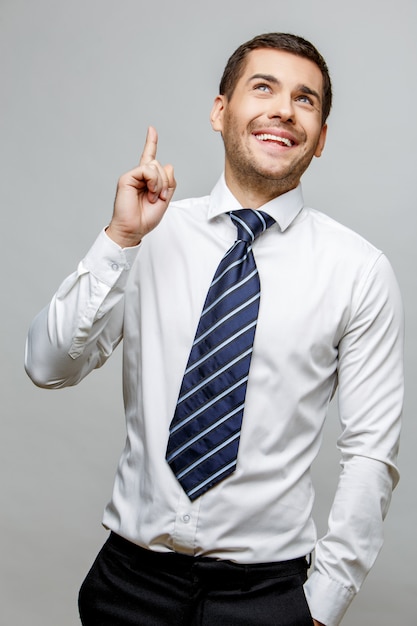 Uomo d'affari alla moda bello su fondo grigio