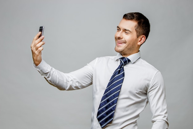 Uomo d'affari alla moda bello su fondo grigio