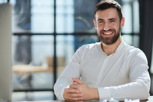 Uomo d'affari allegro in ufficio che esamina lo spazio della copia della macchina fotografica