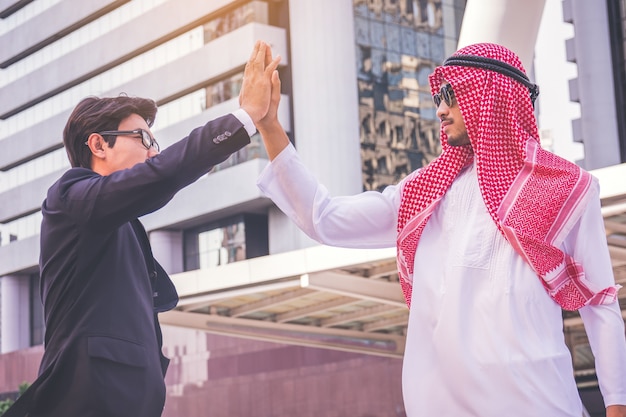 Uomo d&#39;affari arabo che dà il livello cinque al suo socio commerciale, sul cantiere