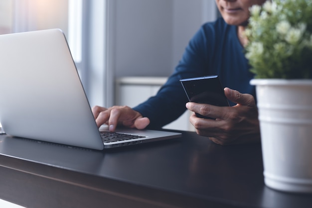 Uomo d'affari asiatico casual in linea che lavora al computer portatile dall'ufficio a casa