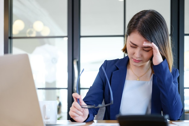 Uomo d'affari asiatico che copre il viso con entrambe le mani con lo stress del lavoro