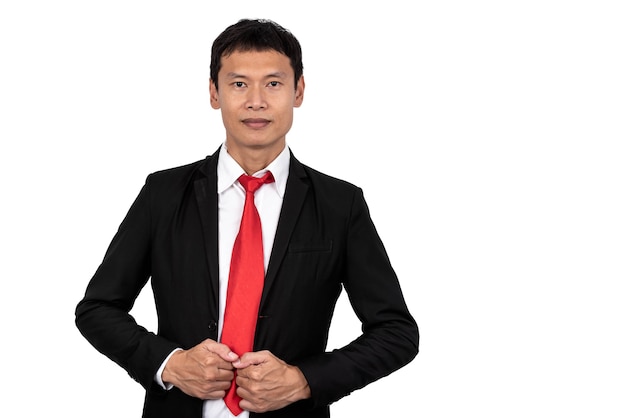 Uomo d'affari asiatico che indossa un abito nero in piedi e sorride su sfondo bianco isolato