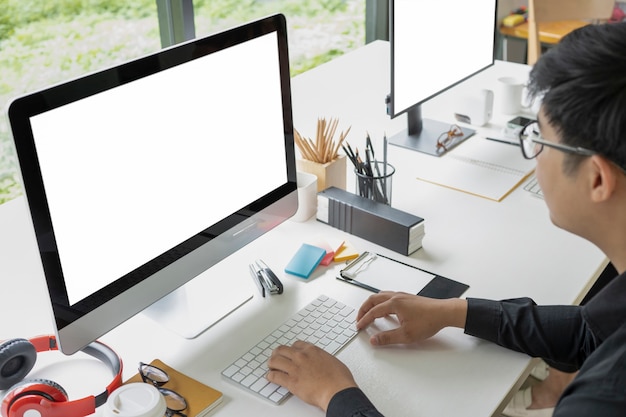 Uomo d'affari asiatico che lavora con il computer in un ufficio moderno.