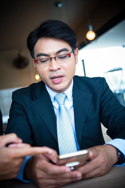 Uomo d'affari asiatico che lavora sul cellulare per obiettivi aziendali e di successo