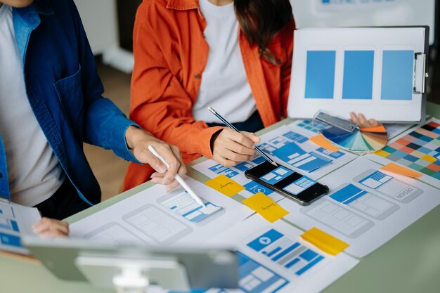 Uomo d'affari asiatico e donna che si incontrano in ufficio Il brainstorming dei dipendenti e il lavoro come piano di squadra e discutono il progetto per punto su carta e tablet
