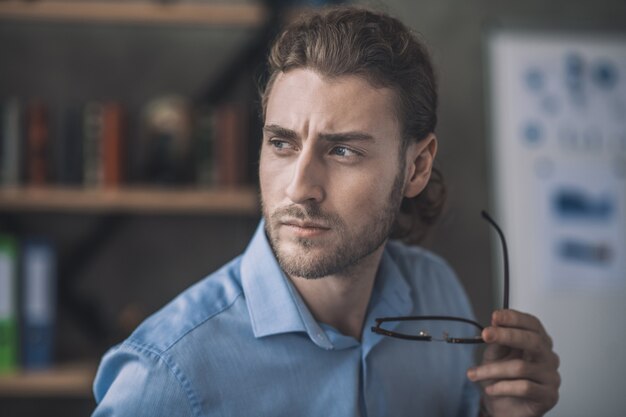 Uomo d'affari barbuto in camicia blu che lavora nell'ambito del progetto