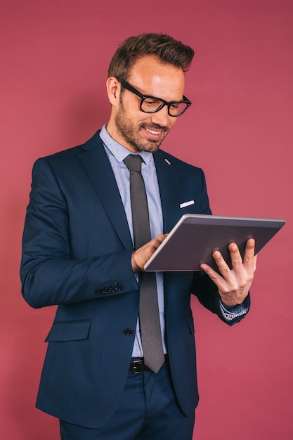 Uomo d'affari bello che lavora in un tablet